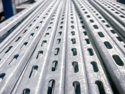 Metallprofile mit Lochung liegen parallel, zeigen Befestigungsartikel für Konstruktionen im Innenausbau.